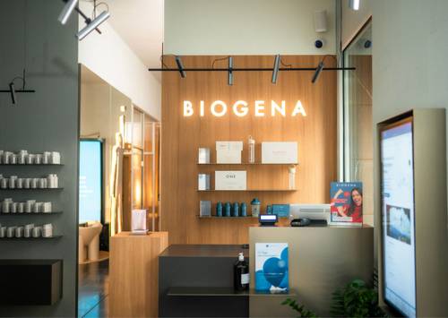 Modernes Ladendesign mit Holzdekor, Regalen mit Produkten und einem leuchtenden „BIOGENA”-Schild an der Wand. Helle und einladende Atmosphäre.