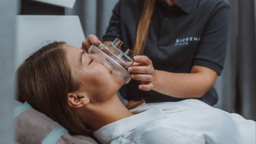 Eine Frau liegt entspannt und erhält eine IHHT-Therapie von einer Spezialistin im BIOGENA PLAZA