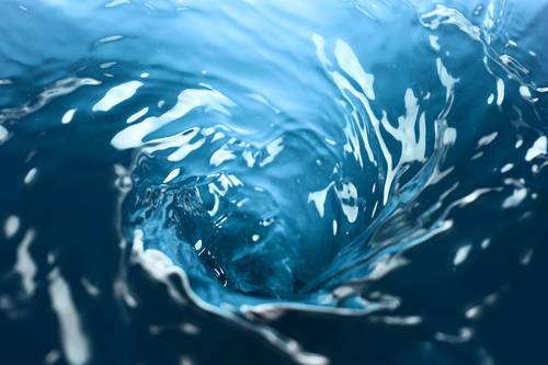 Swirls of blue water form a vortex, with light reflections creating a dynamic, flowing pattern.