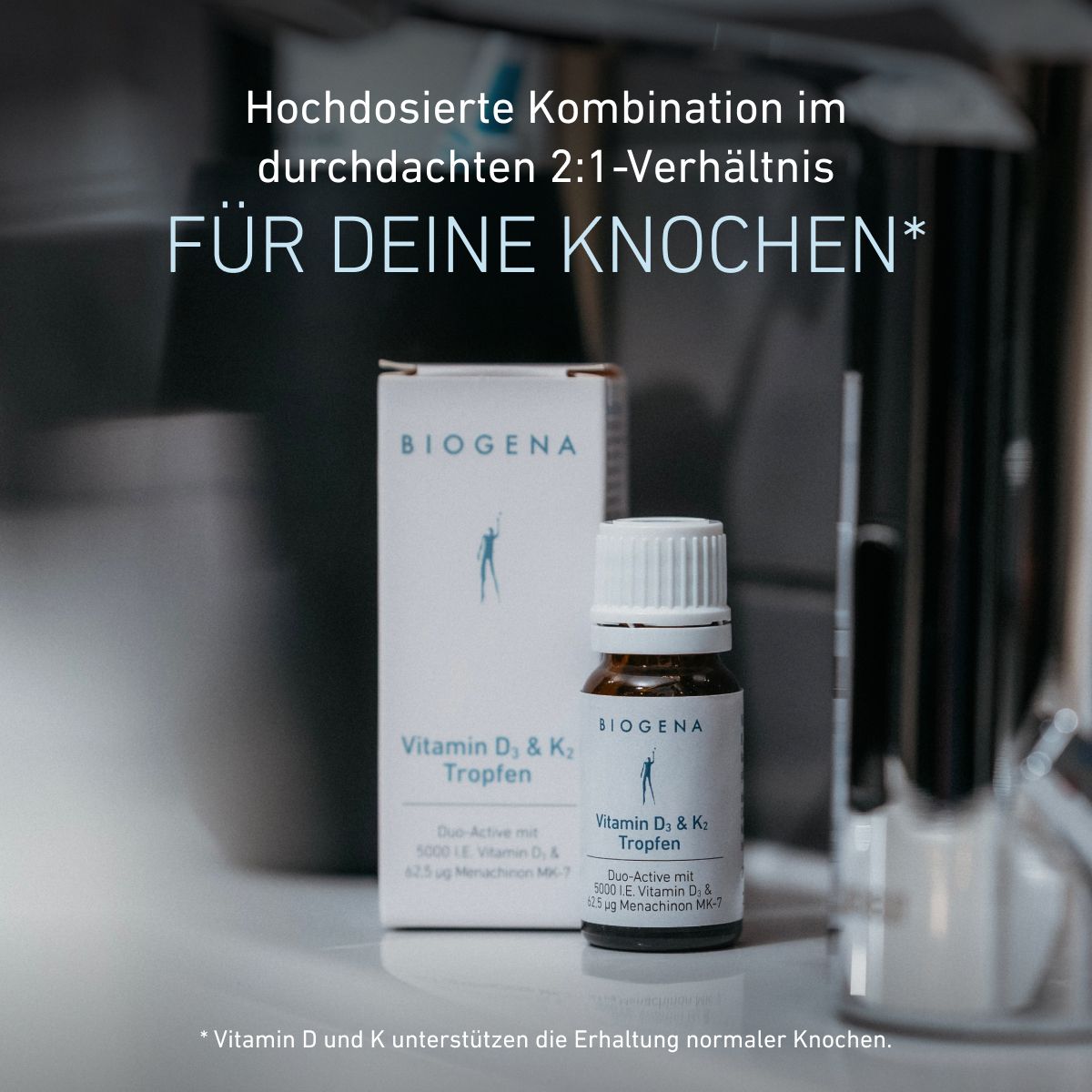 Confezione e flacone delle gocce BIOGENA Vitamina D₃ & K₂ su un piano d'appoggio. Il testo evidenzia la combinazione ad alto dosaggio in rapporto 2:1 e il contributo delle vitamine D e K al mantenimento di ossa normali.