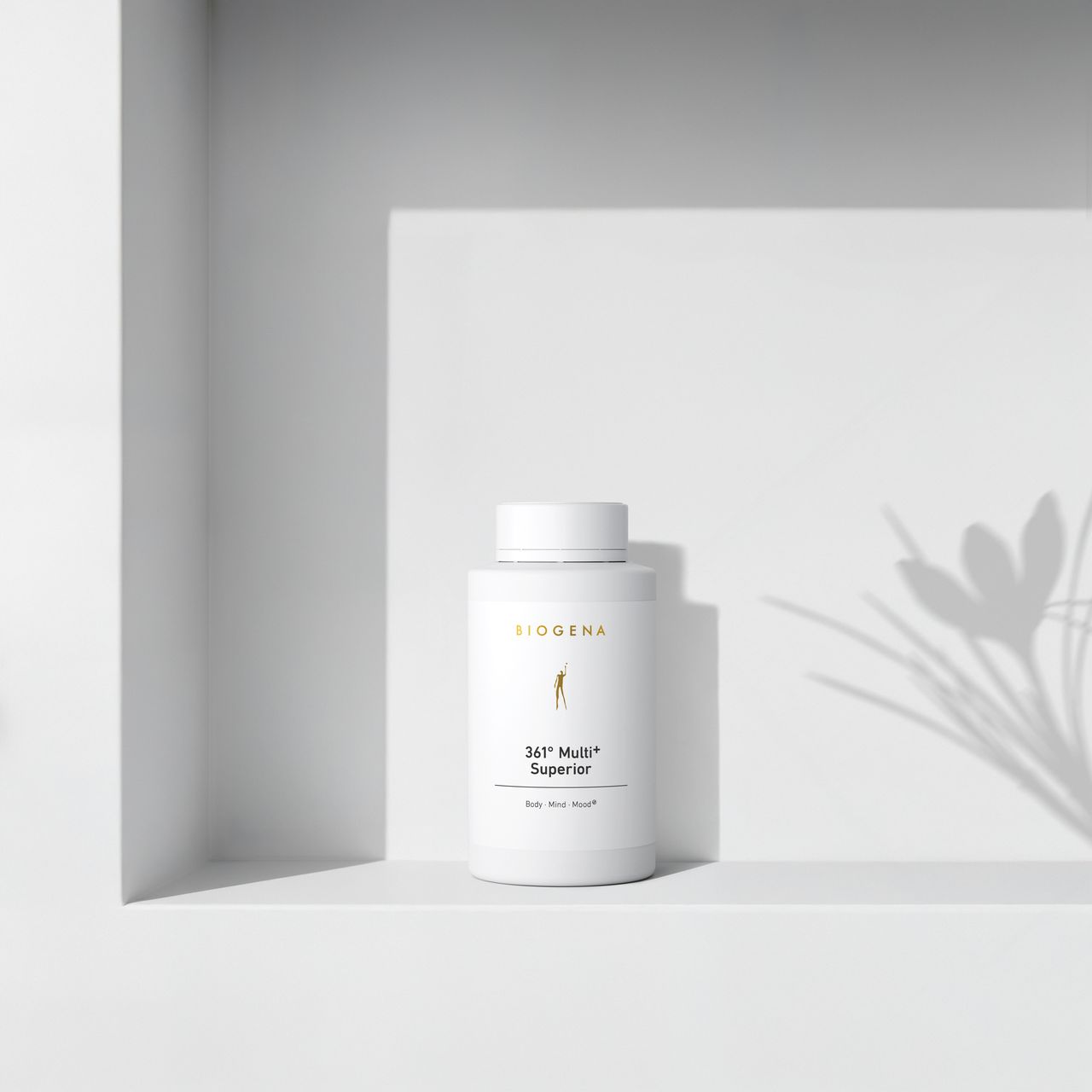BIOGENA 361° Multi+ Superior w białej butelce, ustawiona na półce, z cieniami roślin w tle. Etykieta zawiera napis "Body, Mind, Mood."
