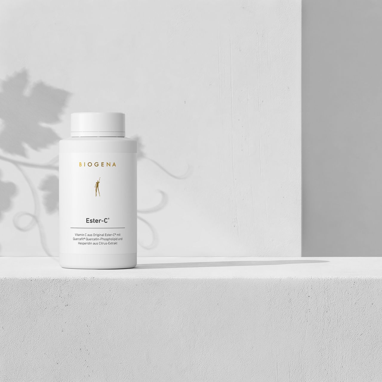 BIOGENA Ester-C® supplement bottle on a minimalist white background with soft plant shadows. Premium vitamin C formula with Ester-C®, quercetin and citrus bioflavonoids.
