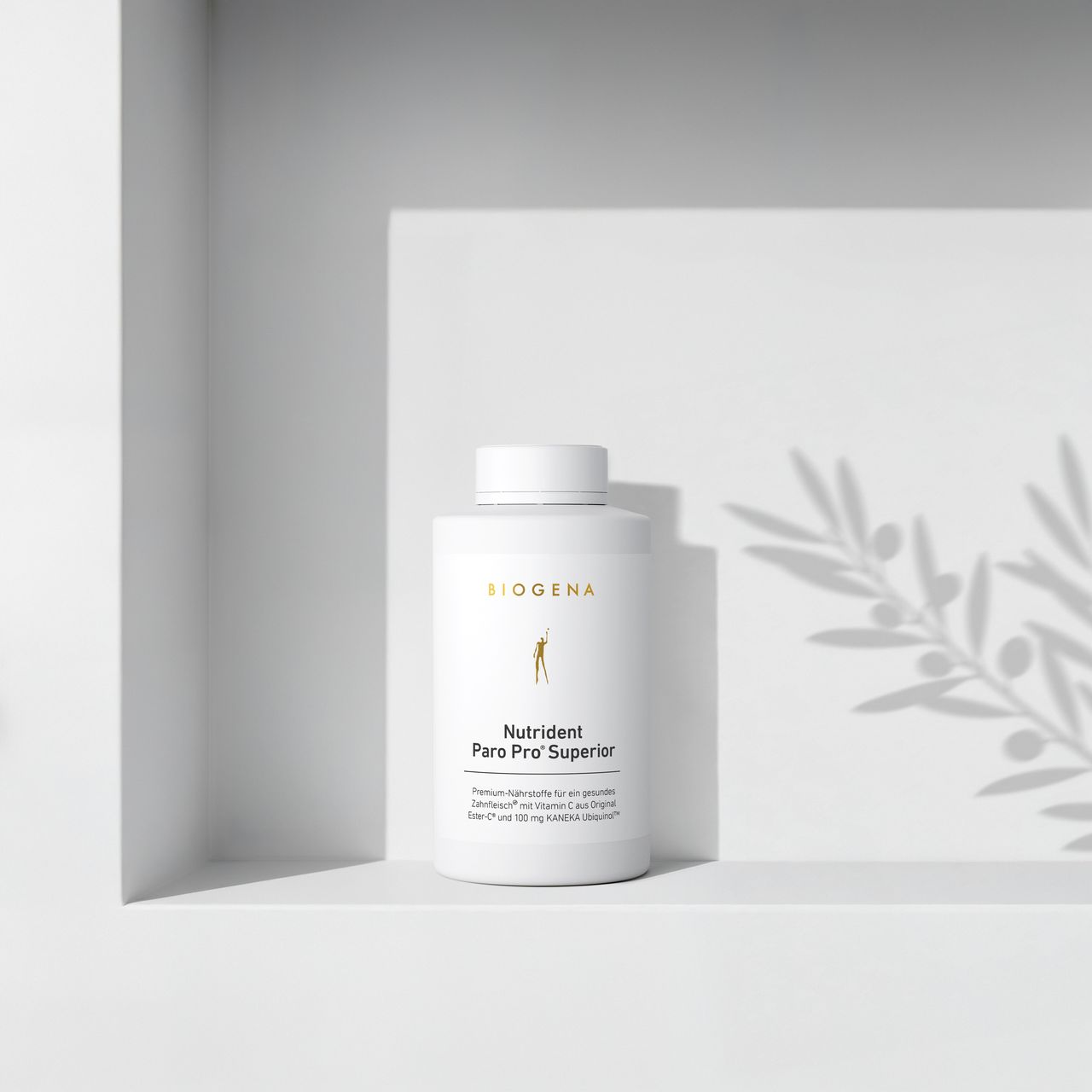 BIOGENA Nutrident Paro Pro® Superior on a minimalist white shelf with soft shadows cast by a plant in the background.