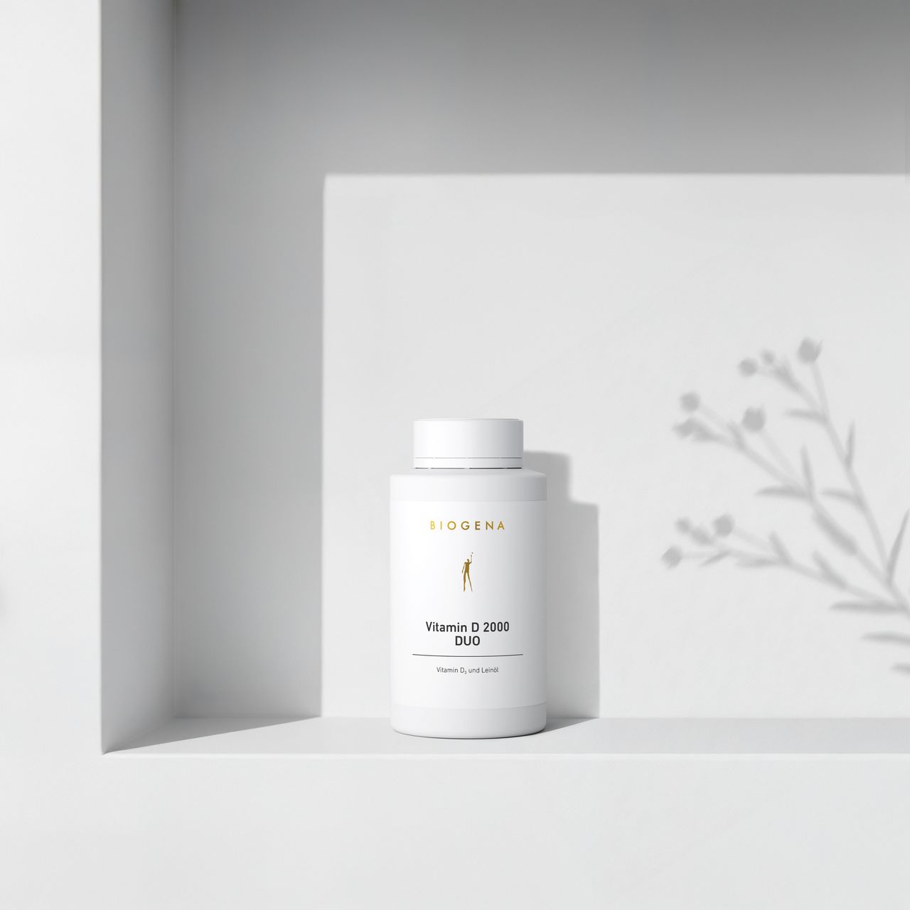 BIOGENA Vitamin D 2000 DUO in a white bottle placed on a shelf, with plant shadows in the background. The label reads "Vitamin D and flaxseed oil."