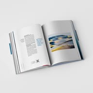 aufgeschlagenes Buch, bedruckte Seiten, Textspalten, QR-Code, ganzseitiges Foto, Seitenstapel, weißer Untergrund