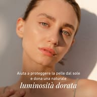 Ritratto di una persona con pelle luminosa in una luce calda. L’immagine evidenzia la protezione della pelle dal sole e un incarnato naturale dall’aspetto radioso e fresco.