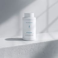 BIOGENA AP Komplex, weiße Kunststoffflasche, auf weißer Ablage, graue Wand, Schatten