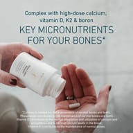 White Biogena Gold Exceptionals Osteo Calbon Complex bottle held in hands with one capsule visible. Highlights calcium, phosphorus, vitamin D, and K for bone and teeth health, normal calcium levels in blood, and overal