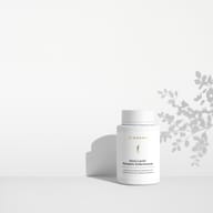 BIOGENA Omni Lactis Metabolic Enterococcus on a minimalist white shelf with soft shadows cast by a plant in the background.