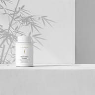 Osteo Calbon Complex® bottle on a minimalist white background with soft shadows creating a calming atmosphere.