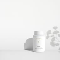 BIOGENA QinkGo® supplement in a white bottle on a minimalist background with light and shadow. Heart & Brain Formula with ginkgo extract and vitamin B1 to support heart and brain function.