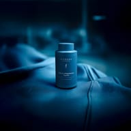 BIOGENA SPORTS Kalium Magnesium Taurin Flasche, auf blauem Stoff, unscharfer Innenraum