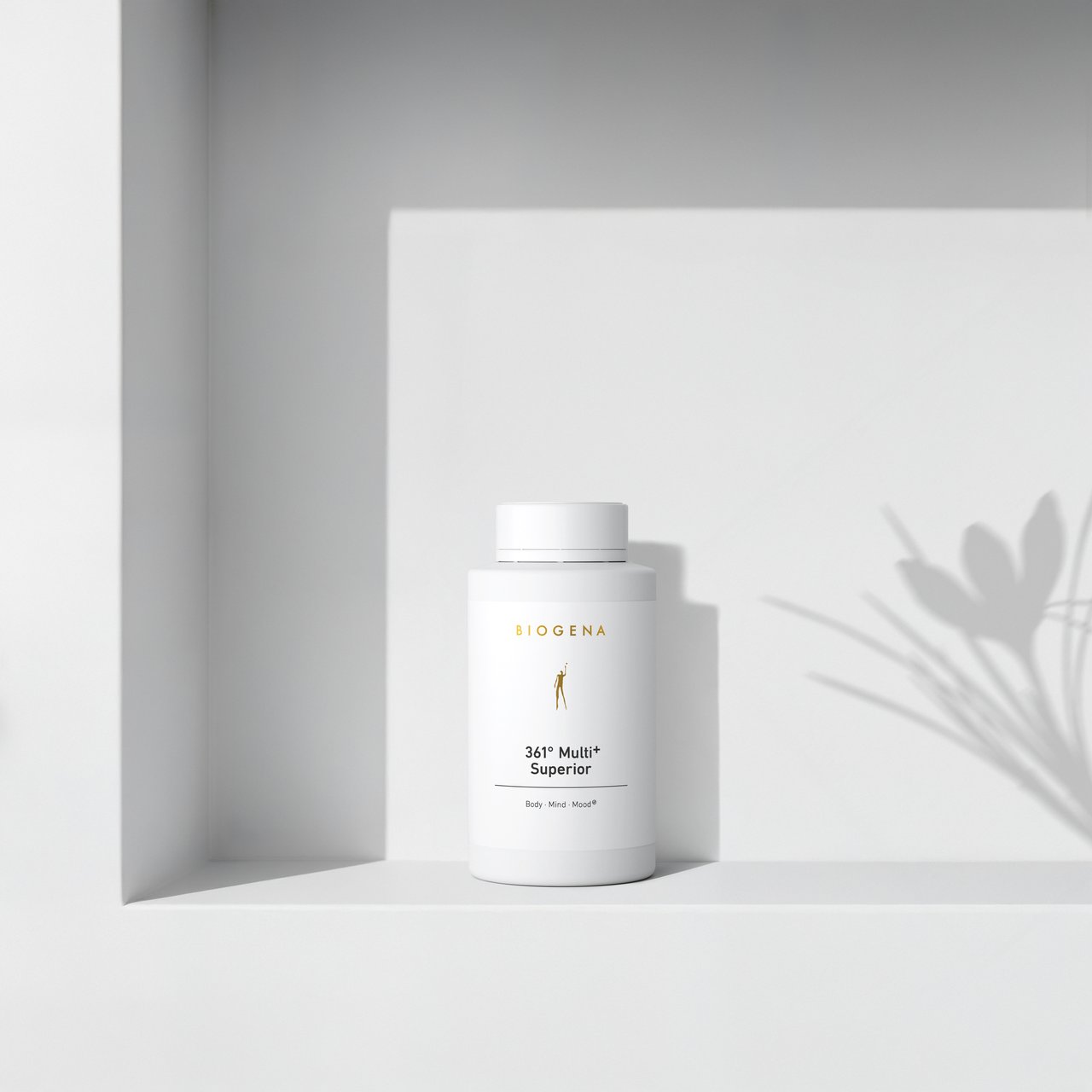 BIOGENA 361° Multi+ Superior într-o sticlă albă, așezată pe un raft, cu umbre de plante în fundal. Eticheta conține textul "Body, Mind, Mood."