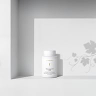 BIOGENA Omni Lactis 20 PUR on a minimalist white shelf with soft shadows cast by a plant in the background.