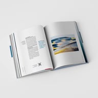 aufgeschlagenes Buch, bedruckte Seiten, Textspalten, QR-Code, ganzseitiges Foto, Seitenstapel, weißer Untergrund