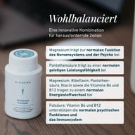 Biała butelka Biogena Antistress Formula® na drewnianym stole, obok otwarta kapsułka, tekst opisujący składniki magnez, kwas pantotenowy, żeń-szeń i witaminy B wspierające nerwy, psychikę i energię.