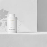 Supliment BIOGENA Ester-C® într-un flacon alb pe fundal minimalist cu umbre de plante. Formulă premium de vitamina C cu Ester-C®, quercetină și bioflavonoide din citrice.