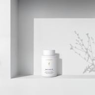 BIOGENA Omni Lactis 20 pe o etajeră albă minimalistă, cu umbre ușoare proiectate de o plantă în fundal.
