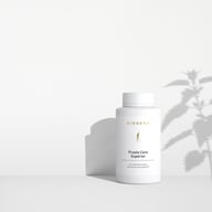 BIOGENA Prosta Care Superior pe un fundal alb minimalist, cu umbre ușoare proiectate de o plantă.
