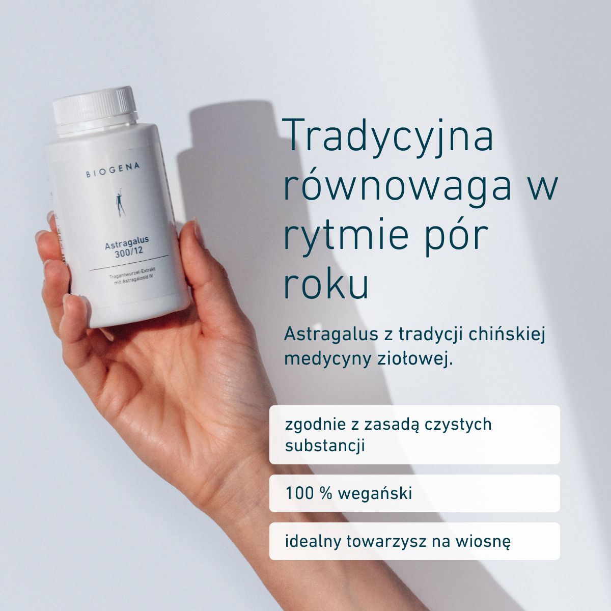 Dłoń trzymająca opakowanie BIOGENA Astragalus 300/12. Wegański suplement z ekstraktem z korzenia traganka, stosowanego w tradycyjnej medycynie chińskiej. Oparty na zasadzie czystych substancji, idealny na wiosnę.