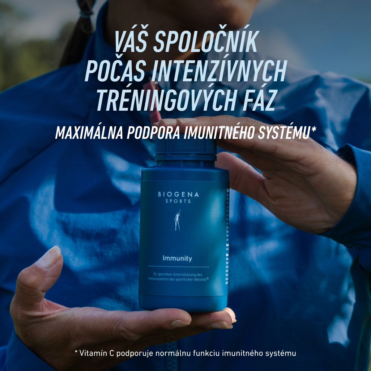 Športovkyňa v modrej bunde drží BIOGENA SPORTS Immunity. Doplnok na podporu imunitného systému počas intenzívneho tréningu. Vitamín C prispieva k normálnej funkcii imunitného systému.