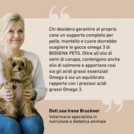 La Dr.ssa Irene Bruckner con un cane raccomanda BIOGENA PETS Omega Tropfen con olio di salmone e semi di canapa per prendersi cura di pelle, pelo e cuore del cane.