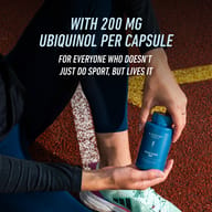 Athlete holding BIOGENA SPORTS Active CoQ10 200 on a running track. High-dose supplement with 200 mg ubiquinol per capsule for people who live and breathe sport.