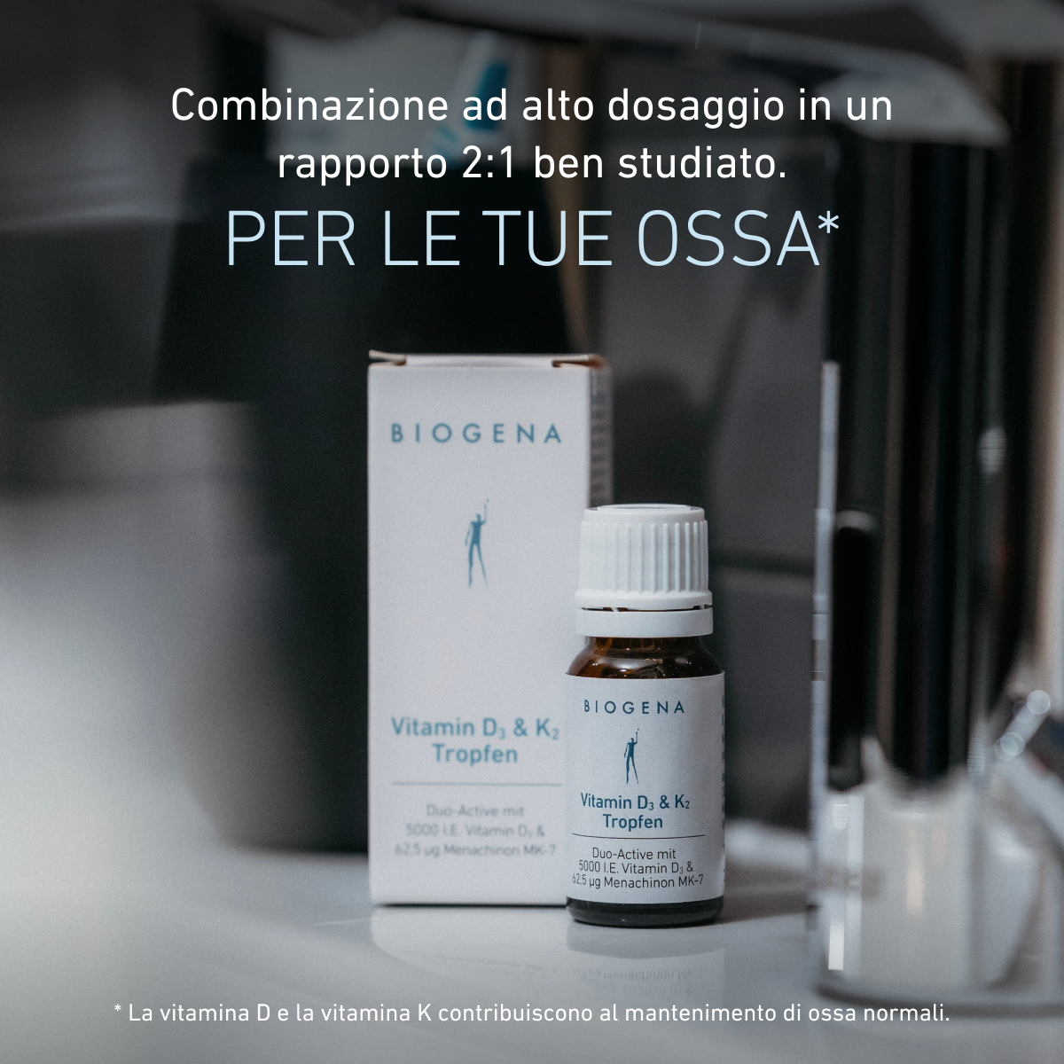Confezione e flacone delle gocce BIOGENA Vitamina D₃ & K₂ su un piano d'appoggio. Il testo evidenzia la combinazione ad alto dosaggio in rapporto 2:1 e il contributo delle vitamine D e K al mantenimento di ossa normali.