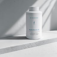 Eine Dose BIOGENA QuattroFerrin® 21 steht auf einer hellen Oberfläche im Sonnenlicht. Das Produkt wird als Eisenpräparat der neuen Generation mit natürlicher Bioverfügbarkeit und guter Verträglichkeit präsentiert.