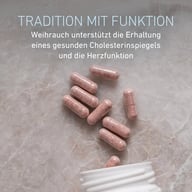 Mehrere rosafarbene Kapseln liegen neben einer geöffneten BIOGENA MiraCHOL® 3.0 Dose. Der Text beschreibt Weihrauch als Unterstützung für die Erhaltung eines gesunden Cholesterinspiegels und einer normalen Herzfunktion.
